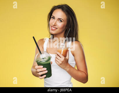 Attraktive lächelnde Frau mit Glas Smoothie mit frischem Saft Stockfoto