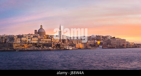 Valletta-Skyline bei Sonnenuntergang mit Basilika von unserer lieben Frau vom Berge Karmel, gesehen von Sliema, Malta Stockfoto