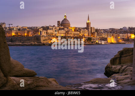 Valletta am Meer bei Sonnenuntergang mit Basilika von unserer lieben Frau vom Berge Karmel, gesehen von Sliema, Malta Stockfoto