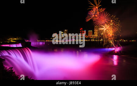 Niagara-Fälle beleuchtet die Wasserfälle nachts an den kanadischen und amerikanischen Seiten. Gelegentlich gibt es Feuerwerke, und dieses Mal war die Victoria Day-o Stockfoto