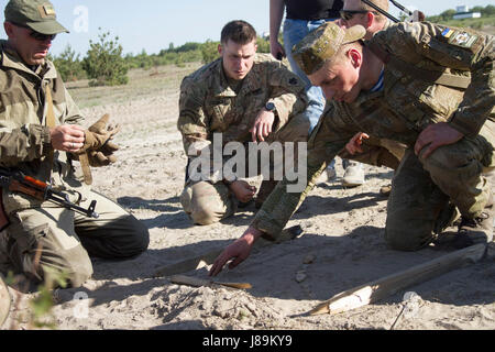 Sgt. Matthew Councill, Mitglied der 45. Infantry Brigade Combat Team zugewiesen, der gemeinsamen multinationalen Trainingsgruppe - Ukraine, hört zu, als ein ukrainischer Soldat sein Team kurz vor der Durchführung Abschnitt Angriff Ausbildung an einer base in der Nähe von Schytomyr, Ukraine, ukrainische am 22. Mai eine Mission gibt.    US-Soldaten aus der 45. Infantry Brigade Combat Team zugewiesen Joint Multinational Training Group - Ukraine arbeiten neben kanadischen Truppen ukrainischen Unteroffiziere in Schytomyr zu trainieren, bevor ihre Bataillon im Yavoriv Combat Training Center für eine 55-Tages-Schulung kommt Stockfoto