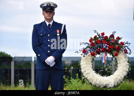 Ein Mitglied der Küstenwache steht vor einem Kranz, bevor es bei einer Gedenkfeier vor einem Bild der Cutter Tampa im Douglas A. Munro Coast Guard Headquarters, Washington, D.C., am 26. Mai 2017 platziert wird. Stockfoto