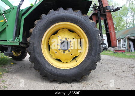 Eine große gelbe Traktorreifen auf einem Zaun-Pfosten-Pfünder Stockfoto
