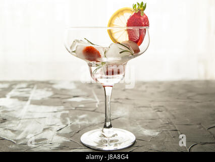 Cocktail aus Erdbeeren und Rosmarin gemacht Eiswürfel in das Glas Stockfoto