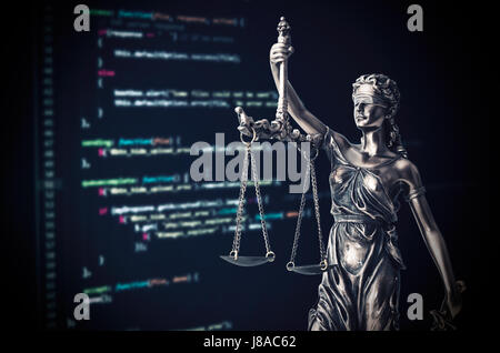 Justiz-Statue mit Code auf Monitor-Gerät im Hintergrund. Code Recht Kriminalität Gerechtigkeit Internet Statue Themis Programmierkonzept Stockfoto