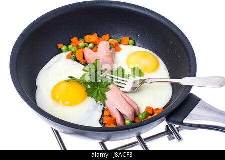 Spiegeleier mit Wurst und Gemüse in der Pfanne auf weiß ba Stockfoto