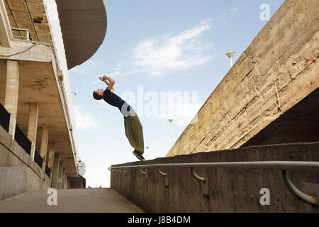 Junger Mann einen Back Flip zu tun. Parkour im urbanen Raum. Sport in der Stadt. Sportliche Aktivität. Stockfoto