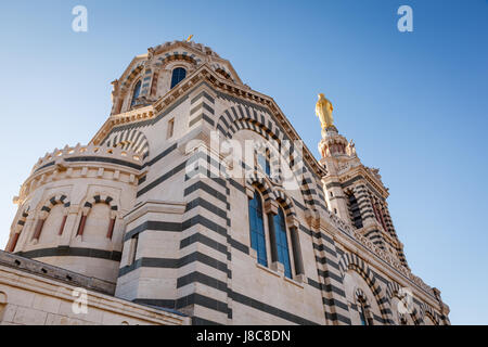 Goldene Statue der Madonna hält das Jesuskind auf der Oberseite Notre-Dame De La Garde in Marseille, Frankreich Stockfoto