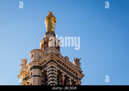 Goldene Statue der Madonna hält das Jesuskind auf der Oberseite Notre-Dame De La Garde in Marseille, Frankreich Stockfoto