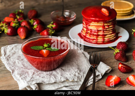 Eine Schüssel mit Erdbeersauce mit amerikanische Pfannkuchen Stockfoto