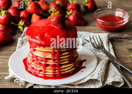 Makro amerikanische Pfannkuchen mit Erdbeer Marmelade auf einem hölzernen Hintergrund. Geringe Schärfentiefe. Stockfoto