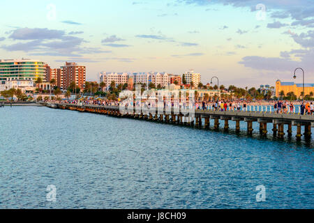 Melbourne, Australien - 28. Dezember 2016: Passanten entlang St. Kilda Beach Pier bei Sonnenuntergang an einem heißen Sommertag Stockfoto