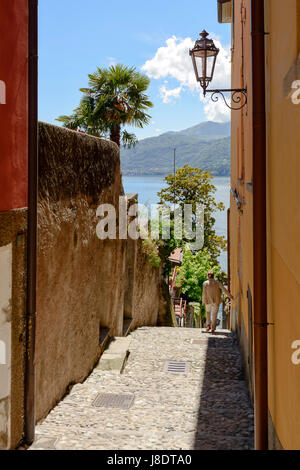 ein unkenntlich Tourist steigt steile Gasse im Feriendorf am Comer See, Varenna, Italien an einem hellen Frühlingstag beschossen Stockfoto