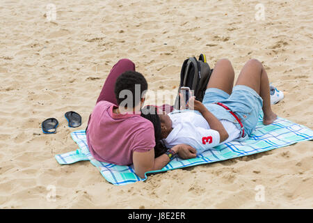 Bournemouth, Dorset, Großbritannien. 28 Mai, 2017. UK Wetter: bedeckt Tag in Bournemouth Strände, die Besucher des Seaside Kopf Die meisten von der Bank Holiday Wochenende zu machen. Junges Paar liegen auf Decke auf dem Sand. Credit: Carolyn Jenkins/Alamy leben Nachrichten Stockfoto