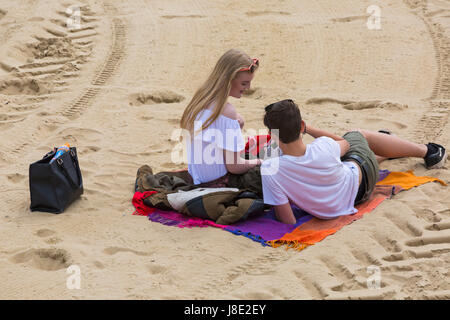 Bournemouth, Dorset, Großbritannien. 28 Mai, 2017. UK Wetter: bedeckt Tag in Bournemouth Strände, die Besucher des Seaside Kopf Die meisten von der Bank Holiday Wochenende zu machen. Junges Paar am Strand sitzen auf Decke auf dem Sand. Credit: Carolyn Jenkins/Alamy leben Nachrichten Stockfoto