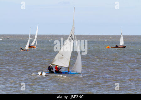 Yacht sailinbg in Morecambe Bay, Lancashire, UK. Mai Sonne bricht durch auf Morecambe Bay Sailing Club Segler mit dem Lake District im Hintergrund. Stockfoto