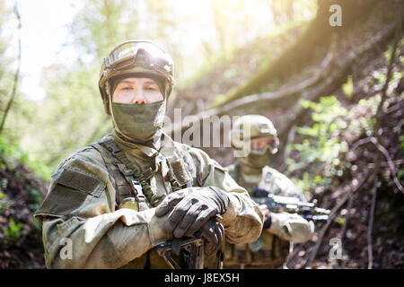 Zwei Soldaten in militärischen Helm und Tarnung mit Gewehr auf Wald-Hintergrund Stockfoto