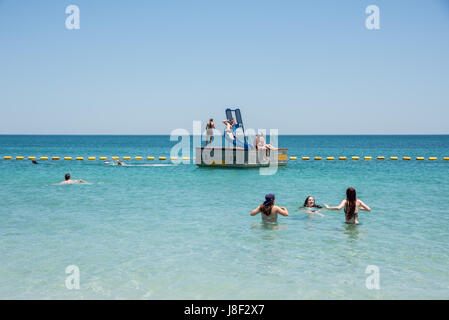 Coogee, WA, Australien-November 14,2016: Person auf Ponton-Wasserrutsche mit anderen Schwimmen im Meer am Coogee Beach in Coogee, Western Australia. Stockfoto