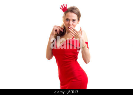 Junge attraktive Frau mit langen blonden Haaren im roten Kleid hält Pappe Stock der roten Krone auf weißem Hintergrund im studio Stockfoto