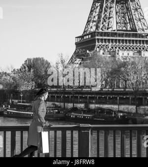 Hell in Paris. Voller Länge Porträt der modernen Frau in roten Trenchcoat am Ufer in Paris, Frankreich Promenade genießen Stockfoto