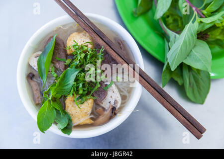 Vegane Version des berühmten Vietnamse-Nudelsuppe Pho, serviert mit frischen Kräutern im buddhistischen lokal, Nha Trang, Vietnam. Stockfoto
