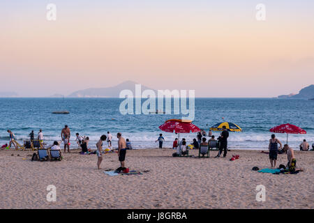 Familien in Hong Kong genießen Sie einen Tag am Strand (Shek O) vor Sonnenuntergang Stockfoto