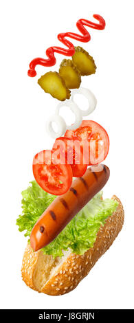 Zutaten für Hot-Dog fallen in der Luft isoliert auf weiss - Grillwurst, frisches Gemüse, Ketchup. Fast-Food zu fliegen Stockfoto