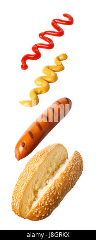 klassische Hot-Dog mit fliegenden Zutaten - gegrillten Würstchen, Ketchup und Senf isoliert auf weißem Hintergrund. Fliegen Sie essen. Fastfood-Konzept Stockfoto