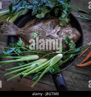 Ein Steinbutt, umgeben von jungem Gemüse; Essen; Fisch; Meeresfrüchte; Plattfische; Zutaten für eine Mahlzeit; Ungekocht; RAW; Gesunde Ernährung; Fischgericht Stockfoto