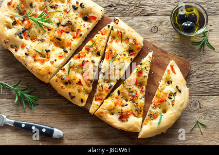 Traditionelle italienische Focaccia mit Tomaten, schwarzen Oliven und Rosmarin - Focaccia hausgemachtes Fladenbrot Stockfoto