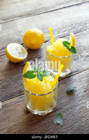 Zitrone Frozen Granita Slush trinken in Gläsern auf rustikalen Holztisch. Hausgemachte italienische Granita Dessert, erfrischende Sommer Matsch zu trinken. Stockfoto