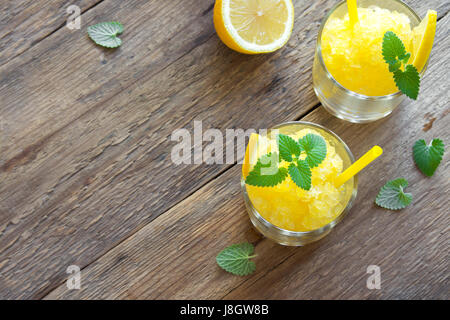 Zitrone Frozen Granita Slush trinken in Gläsern auf rustikalen Holztisch. Hausgemachte italienische Granita Dessert, erfrischende Sommer Matsch zu trinken. Stockfoto