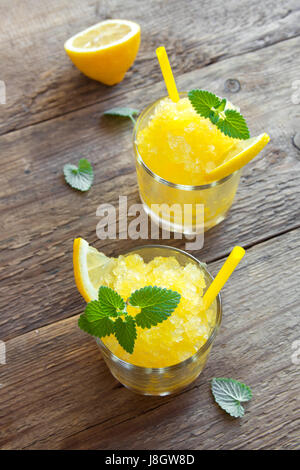 Zitrone Frozen Granita Slush trinken in Gläsern auf rustikalen Holztisch. Hausgemachte italienische Granita Dessert, erfrischende Sommer Matsch zu trinken. Stockfoto