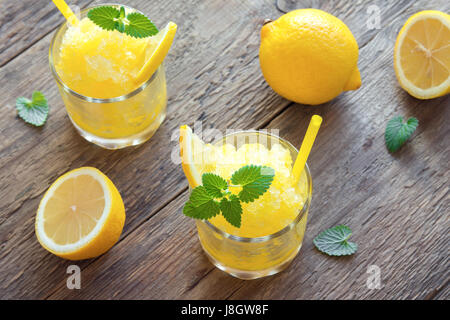 Zitrone Frozen Granita Slush trinken in Gläsern auf rustikalen Holztisch. Hausgemachte italienische Granita Dessert, erfrischende Sommer Matsch zu trinken. Stockfoto