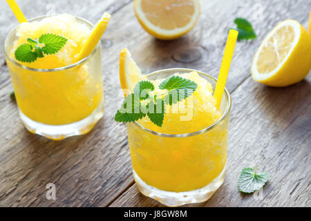Zitrone Frozen Granita Slush trinken in Gläsern auf rustikalen Holztisch. Hausgemachte italienische Granita Dessert, erfrischende Sommer Matsch zu trinken. Stockfoto