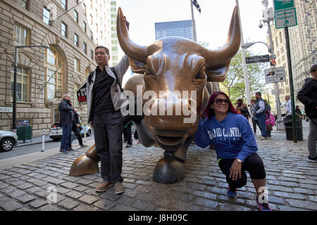 Touristen posieren für Fotos bei Aufladung Stier Skulptur New York Kunst im öffentlichen Raum Bowling Green Broadway Vereinigte Staaten Stockfoto