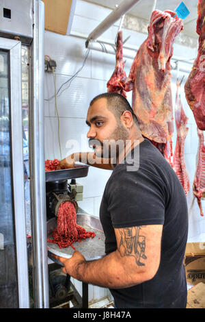 Bandar Abbas, Provinz Hormozgan, Iran - 16. April 2017: der Metzger produziert Hackfleisch mit einem Fleischwolf in einer Metzgerei. Stockfoto