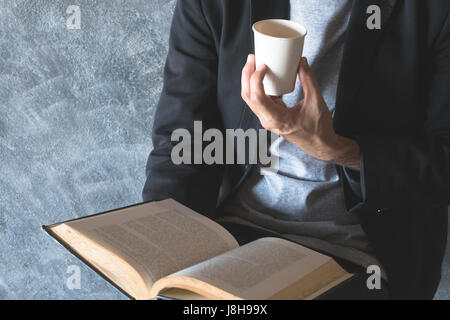 Genießen Sie eine Tasse Papier Kaffee, lesen ruhig. Stockfoto