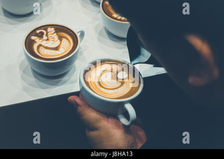 Der Prozess der Herstellung Kaffee Tasse Kaffee mit schönen Latte Kunstformen. Stockfoto