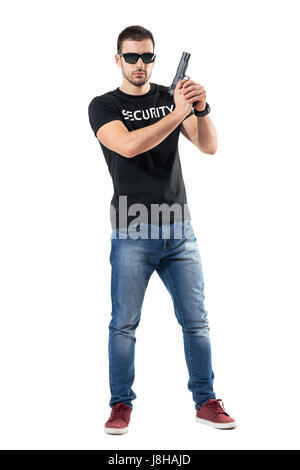 Bereit alarmierte verdeckter Ermittler mit Pistole mit beiden Händen, Blick in die Kamera. Ganzkörper-Länge-Porträt isoliert auf weißem Studio-Hintergrund. Stockfoto