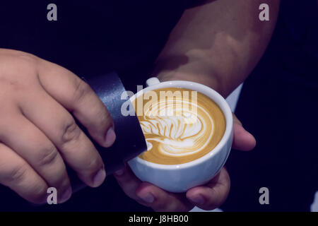 Der Prozess der Herstellung Kaffee Tasse Kaffee mit schönen Latte Kunstformen. Stockfoto