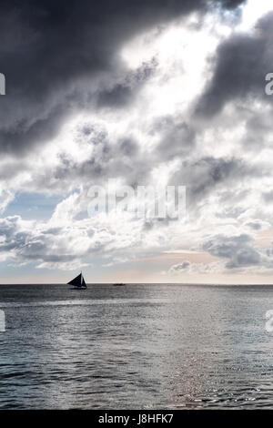 einsamen Segelboot auf dem offenen Meer bei Sonnenuntergang Stockfoto