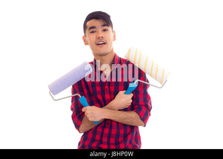 Schöner junger Mann mit dunklen Haaren in Rot kariertes Hemd mit farbigen rollt auf weißem Hintergrund im studio Stockfoto