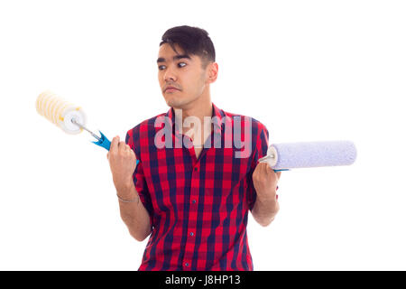 Junge ernster Mann mit dunklen Haaren in Rot kariertes Hemd mit farbigen rollt auf weißem Hintergrund im studio Stockfoto