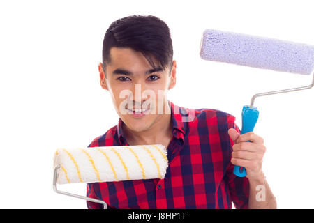 Junger lächelnder Mann mit schwarzen Haaren in Rot kariertes Hemd mit farbigen rollt auf weißem Hintergrund im studio Stockfoto