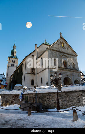 Vollmond über mittelalterliche Kirche auf den zentralen Platz Megeve, Französische Alpen Stockfoto