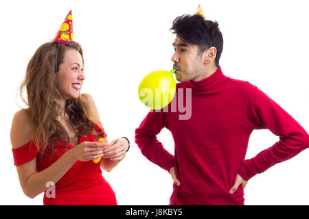 Junges Paar bläst Luftballons Stockfoto