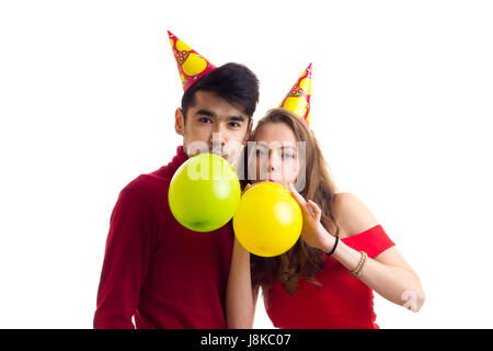 Junges Paar bläst Luftballons Stockfoto