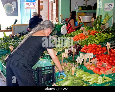 Kretische Standbesitzer Sortierung Gemüse auf einem Markt stall im Stadtzentrum, Heraklion, Kreta, Griechenland, Europa. Stockfoto