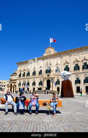 Blick auf die Auberge de Castille in Castille Square mit dem Bianco Carrara Marmor Skulptur und Touristen sitzen auf einer Bank im Vordergrund, Vallett Stockfoto